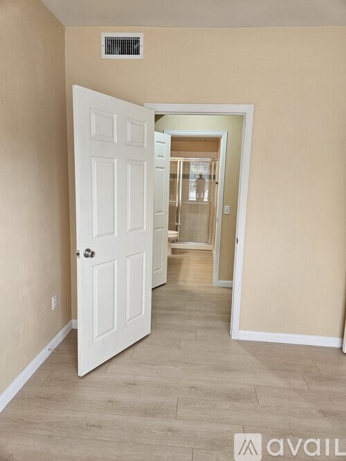 A hallway with a white door and a white interior.