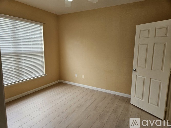 A room with a white door and a window with blinds.
