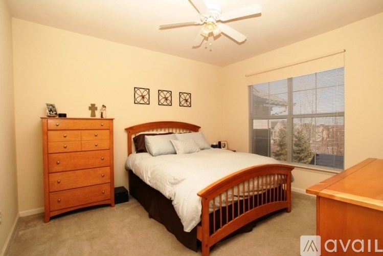 A bedroom with a bed, dresser, and window.
