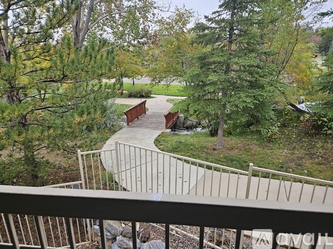 A view from a balcony overlooking a bridge and trees.