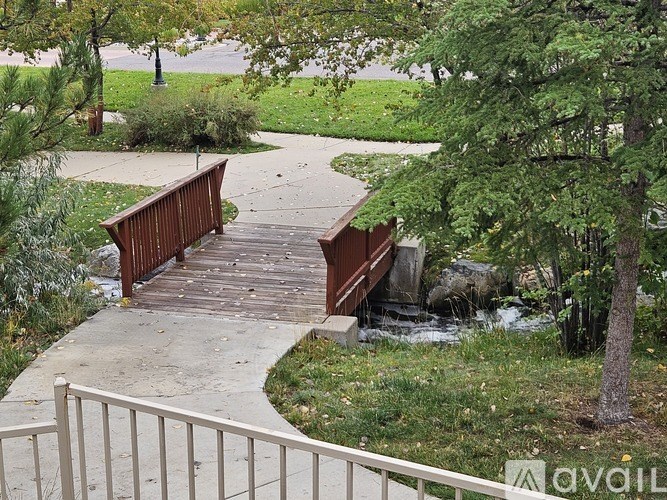 A wooden bridge over a stream in a park.