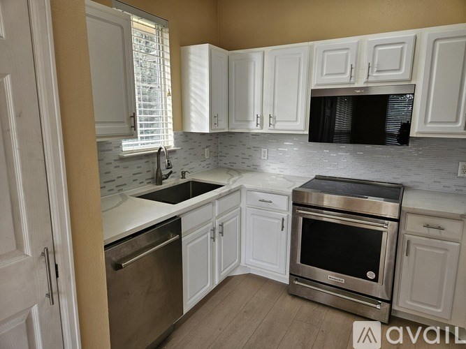 A kitchen with white cabinets and stainless steel appliances.