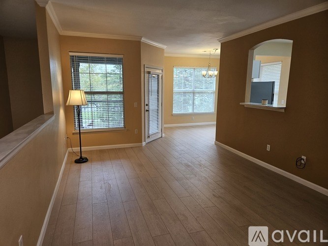A room with a wooden floor and a lamp on the floor.