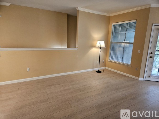 A room with wooden flooring and a window with blinds.