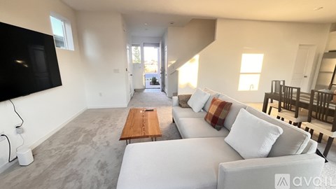A living room with a white couch and a wooden table.