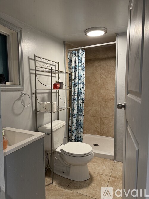 A bathroom with a toilet, sink, and shower curtain.