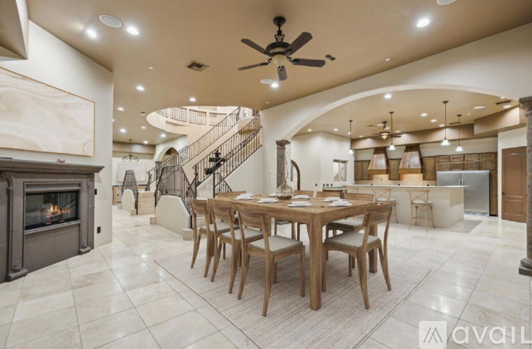 A spacious dining room with a wooden table and chairs.