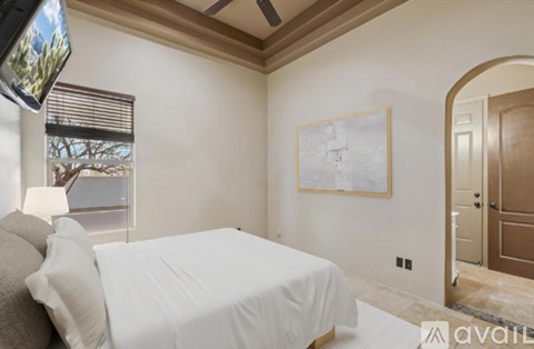 A bedroom with a large bed and a painting on the wall.