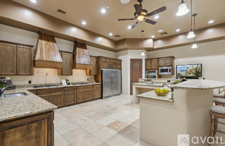 A kitchen with a large island and a refrigerator.