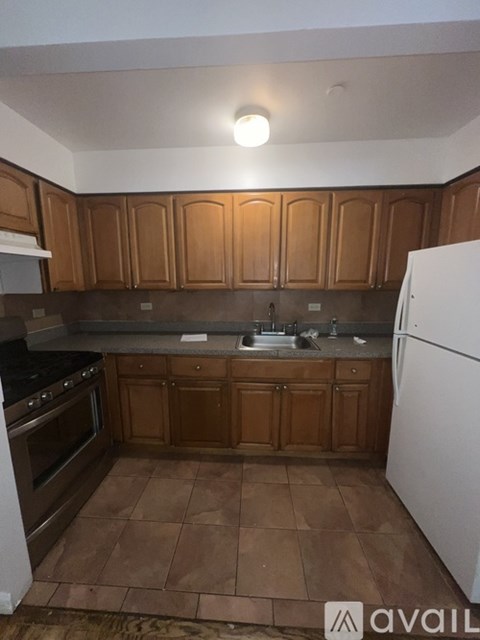 A kitchen with brown cabinets and a white fridge.