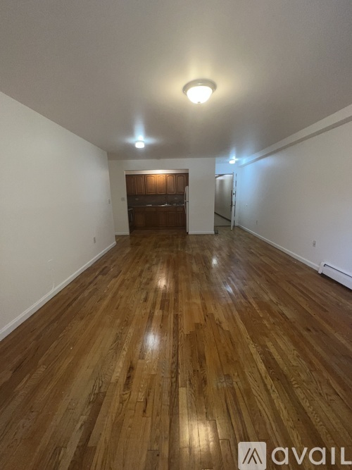 A room with wooden flooring and a white wall.