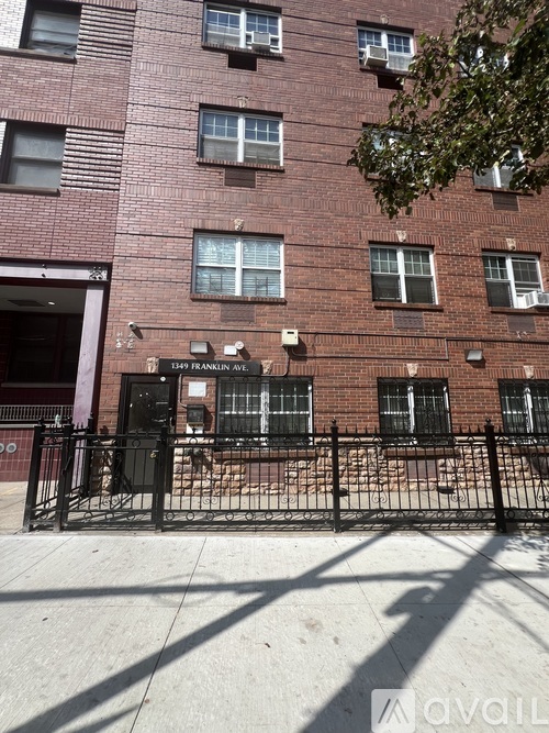 A red brick building with a black gate in front.