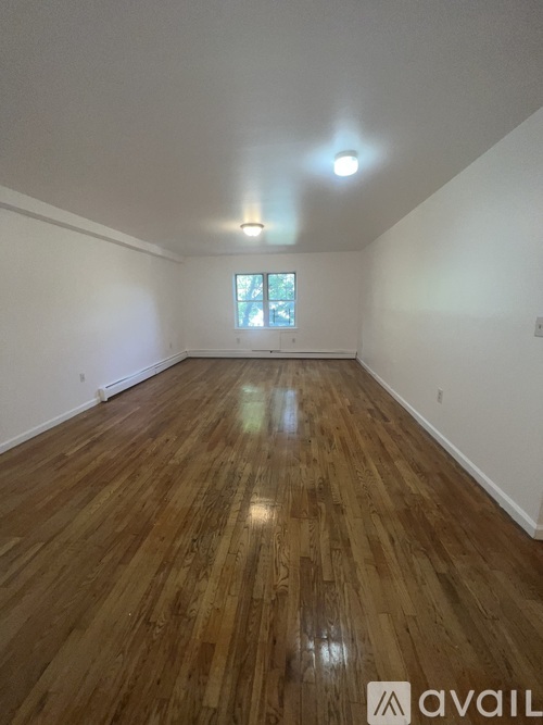A room with wooden flooring and a window.