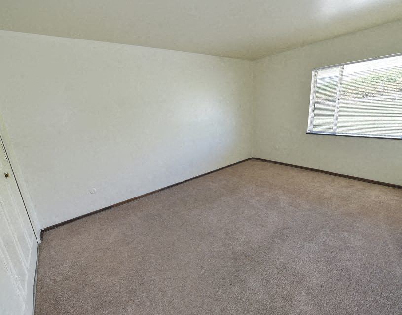 an empty room with a window and a carpet