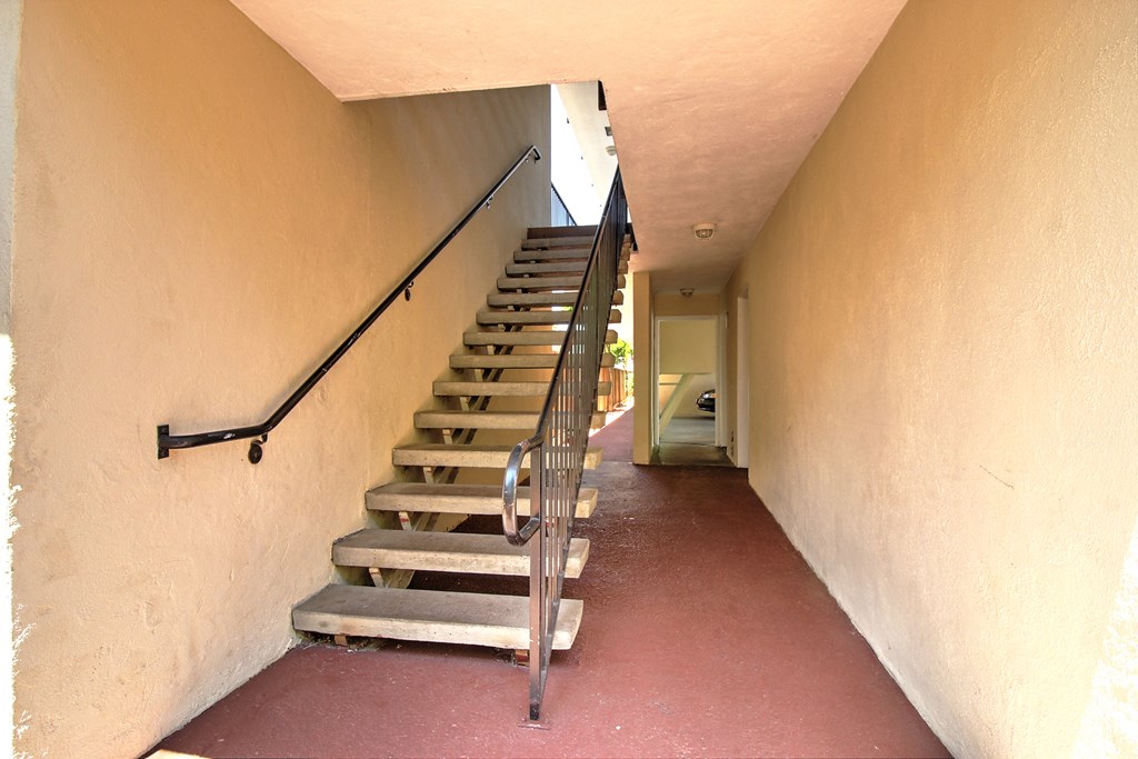 a set of stairs leading up to a hallway with a railing
