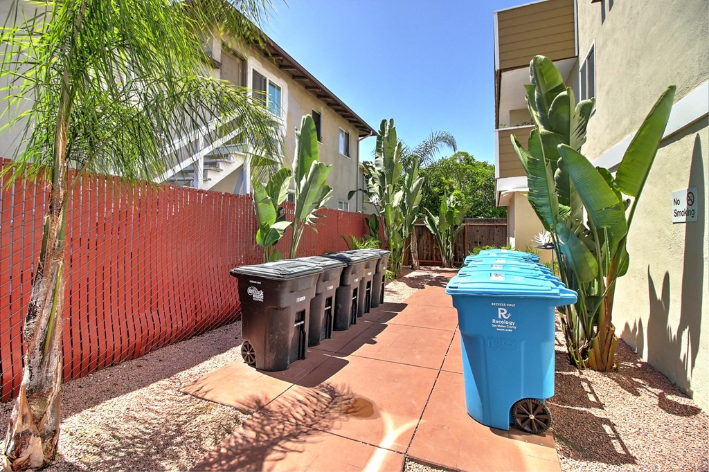 a row of trash cans in front of the building