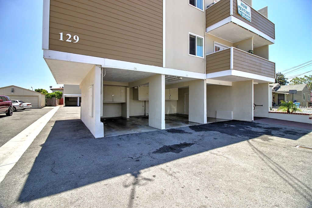 a view of the front of an apartment building with a parking lot