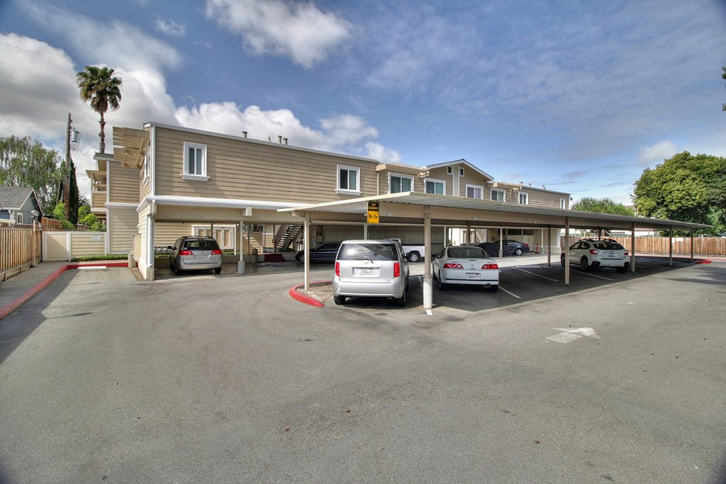 A parking lot with cars and a building in the background.