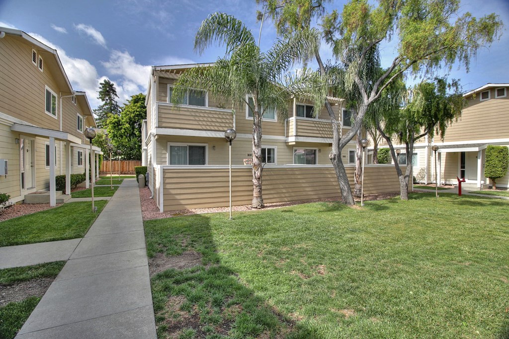 A row of houses with a sidewalk in front.