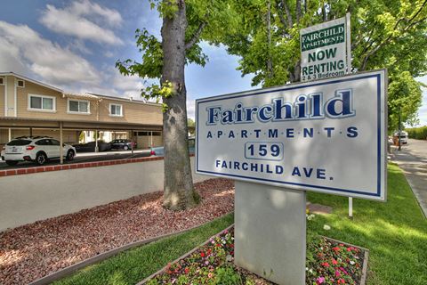 a fairchild apartments sign in front of a tree
