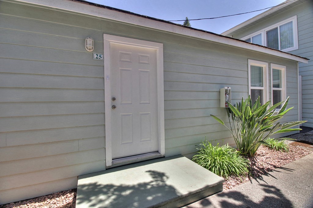 A small house with a white door and a small window on the side.