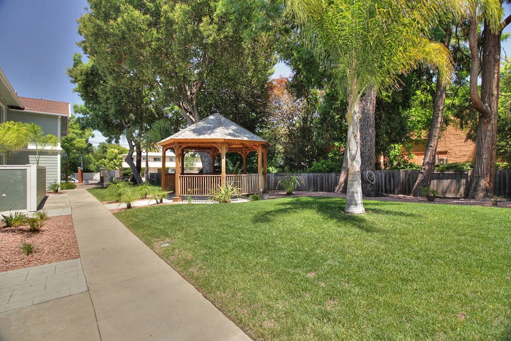 A gazebo is in the middle of a grassy area.