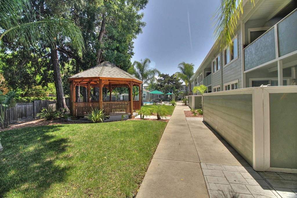 A gazebo is in the middle of a grassy area.