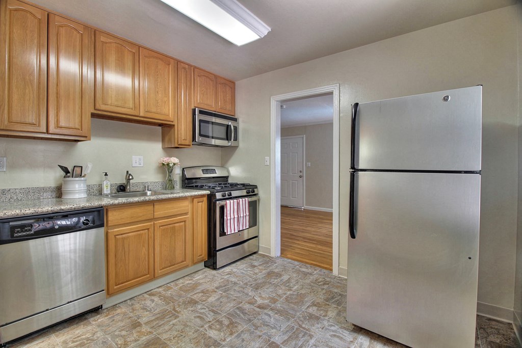 A kitchen with wooden cabinets and stainless steel appliances.