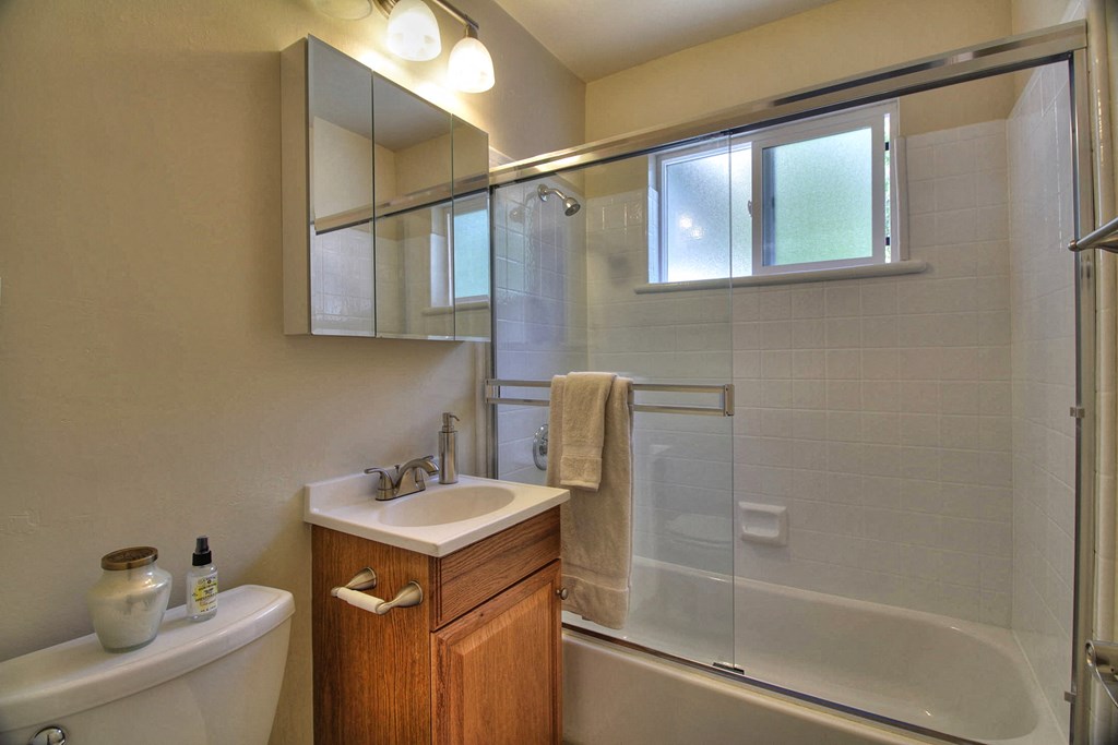 A bathroom with a white sink and a white tub.