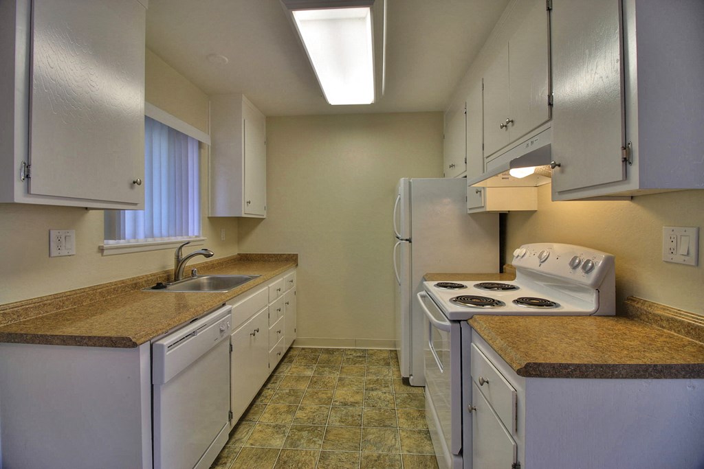 a kitchen with white appliances and granite counter tops