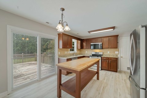 A kitchen with wooden cabinets and a wooden table.