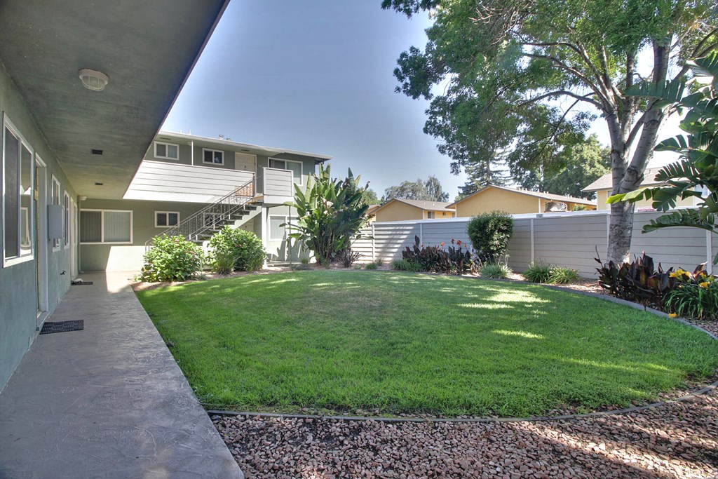 A house with a well-maintained lawn and a gravel pathway leading to the front door.