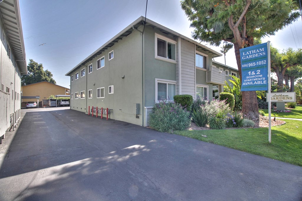 A street view of a residential area with a sign for Latellum Gardens.