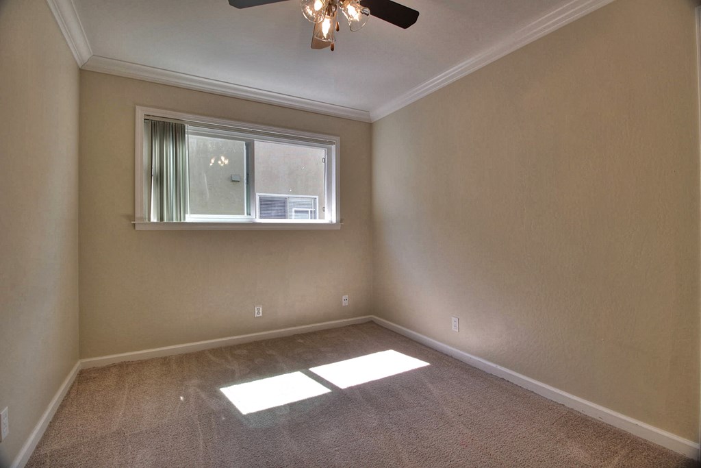 A room with a window and a ceiling fan.