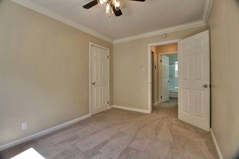 a living room with two doors and a ceiling fan