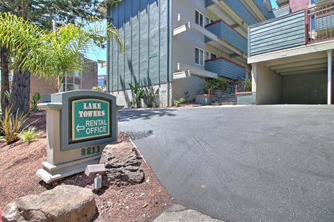 A sign for Lake Towers Rental Office is in front of a building.