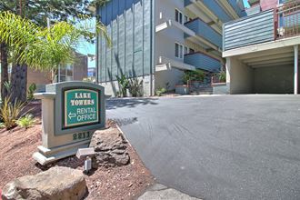 a parking lot with a sign for the laneway entrance to an apartment building
