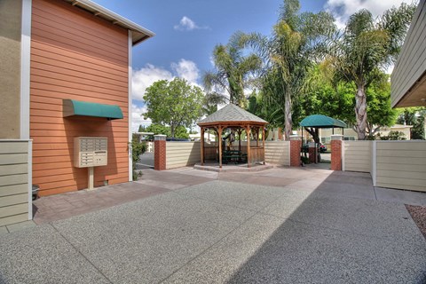 a courtyard with a gazebo and a building with trees