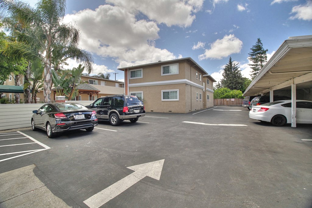 a large parking lot with cars in front of a house