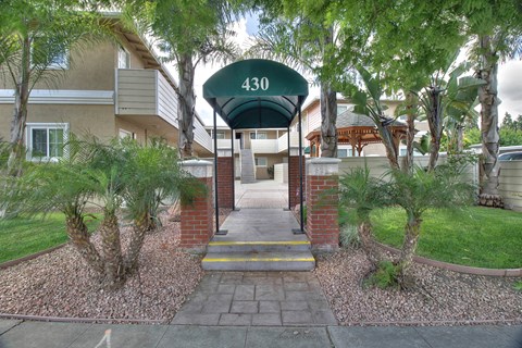 The entrance to apartment 430 is surrounded by trees and shrubbery.