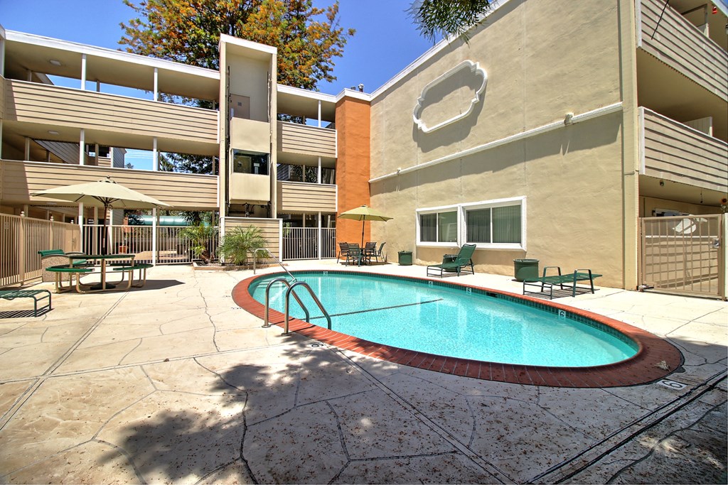 A pool in a courtyard surrounded by buildings.