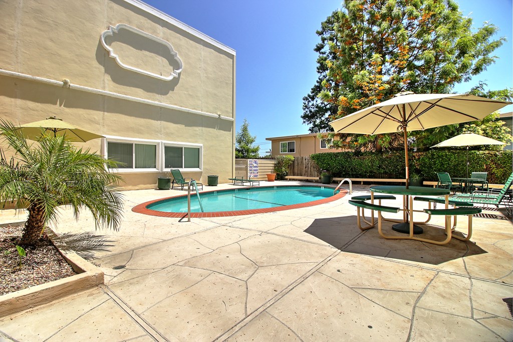 A pool with a table and chairs around it.