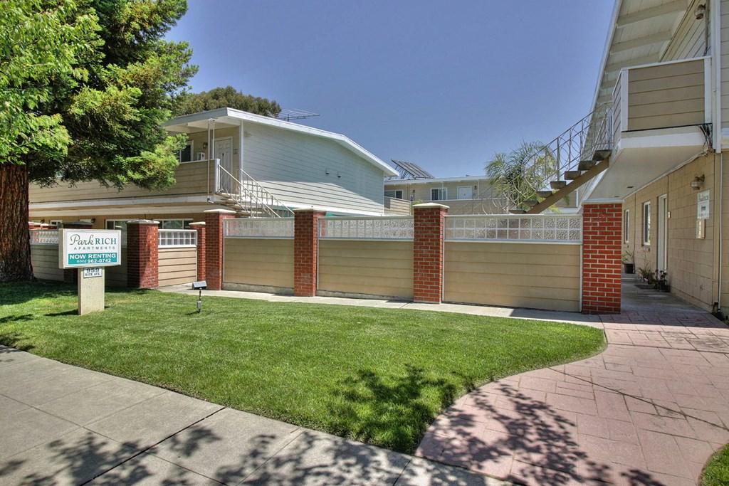 A house with a garage and a tree in front.