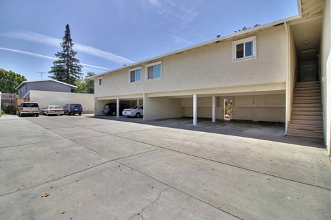 A large parking lot in front of a two-story building with a garage.