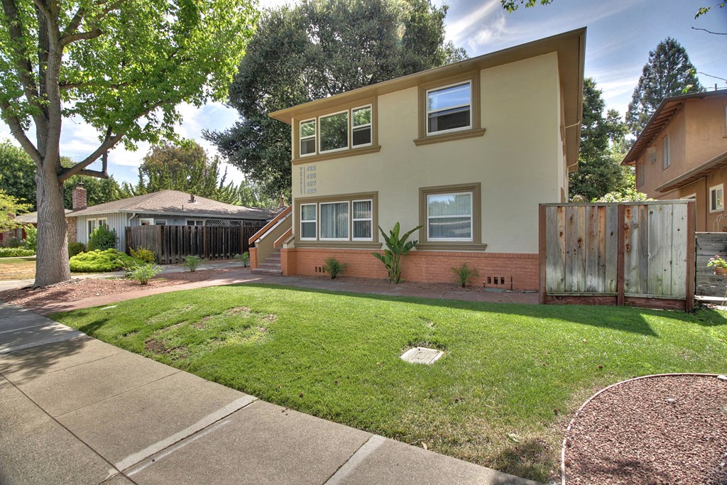 a house with a yard and a sidewalk in front of it