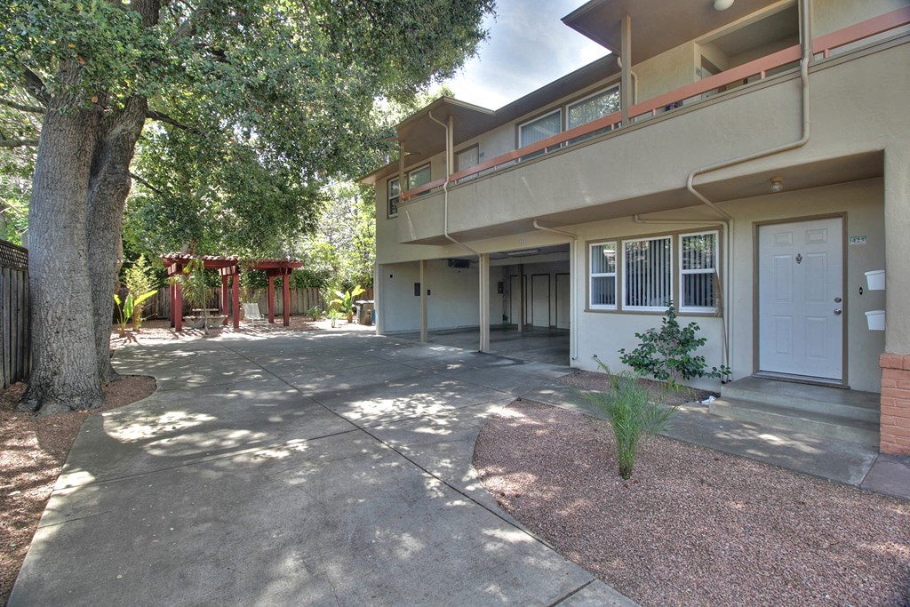 the front of a house with a driveway and a tree