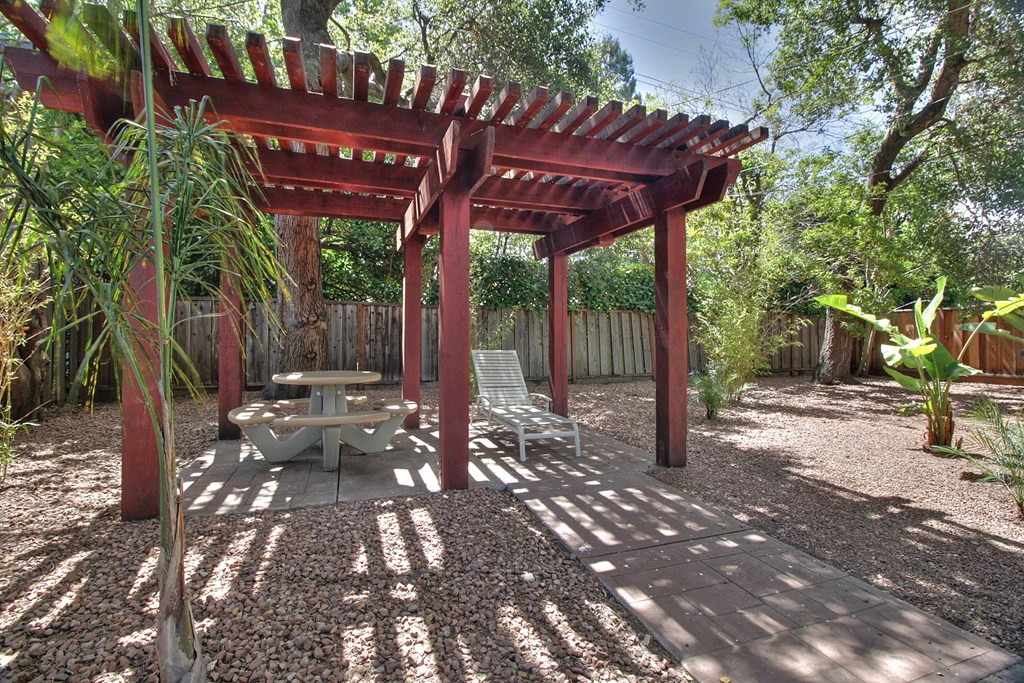 a covered patio with a picnic table and a pergola