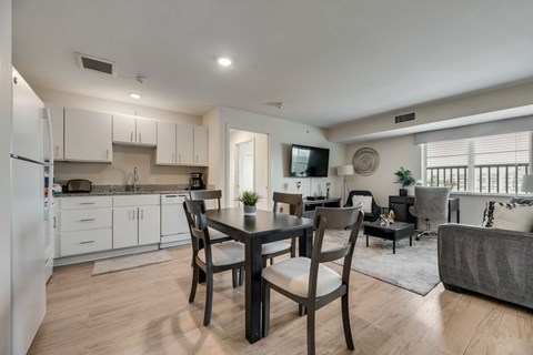 A modern kitchen with a dining table and chairs.
