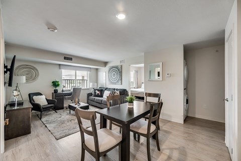 A modern dining room with a dark wood table and chairs.