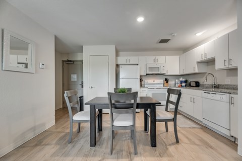 A modern kitchen with a dining table and chairs.